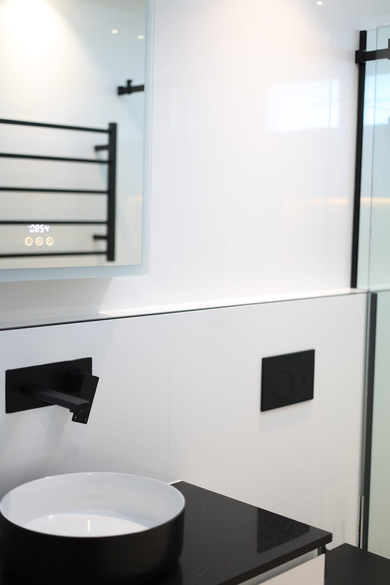 Bathroom vanity with matte-black tapware and heated towel rail
